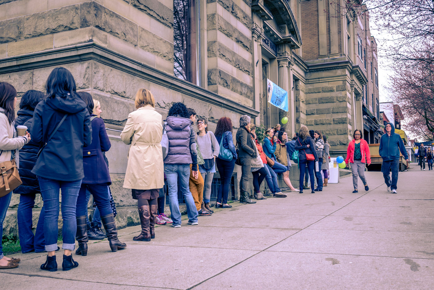 Shoppers lined up along the stone wall of Heritage Hall before the doors open.